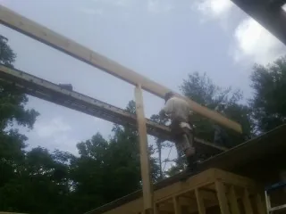 Carpenter setting a ridge beam over a new addition frame — Ice Dam Removal by Roofing Brothers in Catonsville