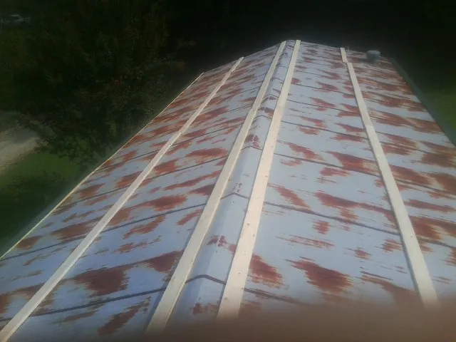 Rusted metal roof panels with new wood purlins before replacement — Storm Damage Roof Repair in Catonsville by Roofing Brothers