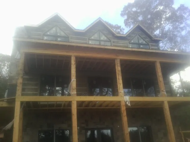 Dormers and porch framing on a large log home under construction — Roof Coating work by our crew in Catonsville
