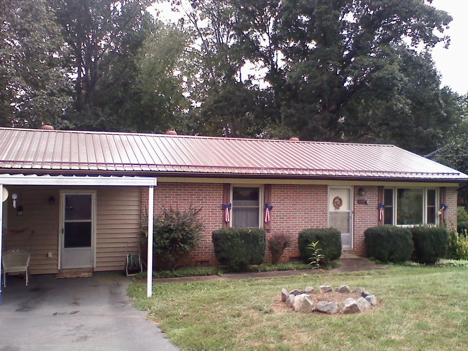 Bronze metal roof and carport on a brick ranch home — Roof Repair work by our crew in Catonsville